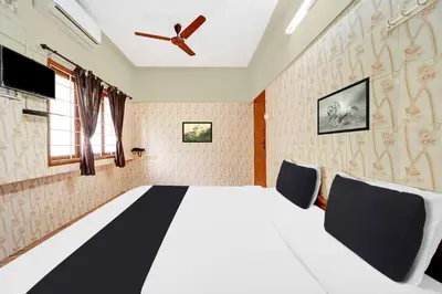a bedroom with a large bed with a ceiling fan at Collection O Central Railway Station Tiruppur in Tiruppūr