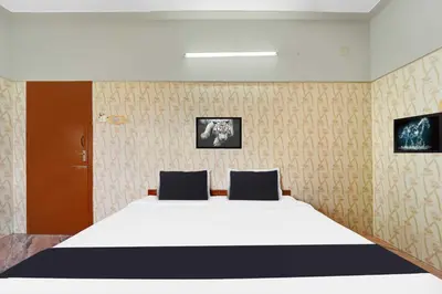 a bedroom with a large white bed with two pillows at Collection O Central Railway Station Tiruppur in Tiruppūr