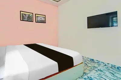 a bedroom with a bed and a flat screen tv at Collection O Ooty Government Rose Garden in Ooty