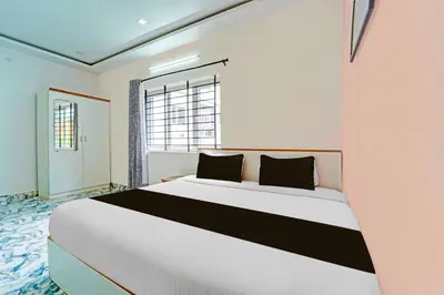 a bedroom with a large white bed and a window at Collection O Ooty Government Rose Garden in Ooty