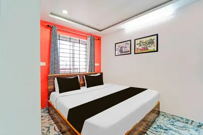 a bedroom with a bed with red walls and a window at Collection O Ooty Government Rose Garden in Ooty