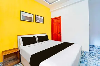 a bedroom with a bed with a yellow wall at Collection O Ooty Government Rose Garden in Ooty