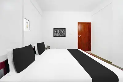 a bedroom with a black and white bed and a wooden door at Collection O Waynad Near Sulthan Bathery in Wayanad