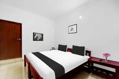 a bedroom with a black and white bed and two tables at Collection O Waynad Near Sulthan Bathery in Wayanad