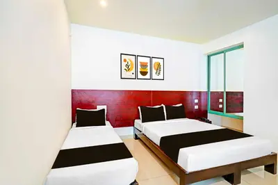 a bedroom with two beds and a red wall at Collection O Teresian College Mysore in Mysore
