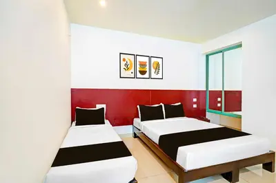 two beds in a room with red and white walls at Collection O Teresian College Mysore in Mysore