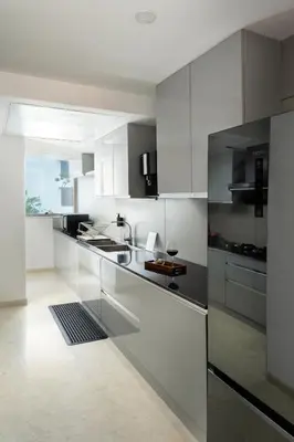 a kitchen with white cabinets and stainless steel appliances at Quad One in Kozhikode