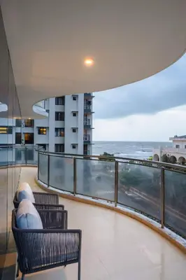 a balcony with two benches and a view of the ocean at Quad One in Kozhikode