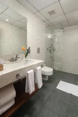 a bathroom with a sink and a toilet and a mirror at Quad One in Kozhikode