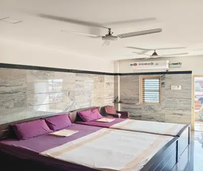 a bedroom with a large bed with purple pillows at Prm classic lodge in Erode
