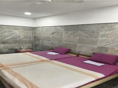 a bedroom with two beds with purple sheets at Prm classic lodge in Erode