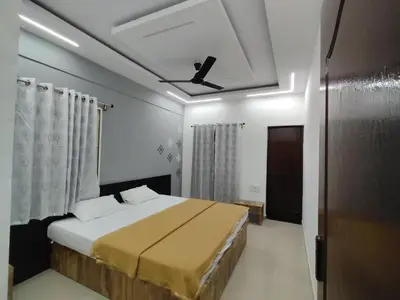 a bedroom with a bed and a ceiling fan at Nandan Suits in Mysore