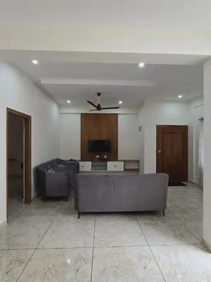 a living room with couches and a ceiling fan at Nandan Suits in Mysore