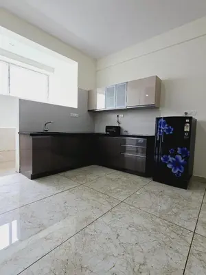 a kitchen with a black refrigerator in a room at Nandan Suits in Mysore