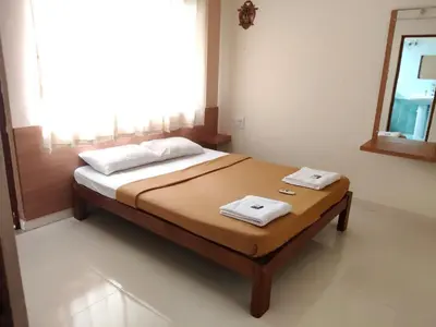 a bedroom with a bed with two towels on it at Nandan Suits in Mysore