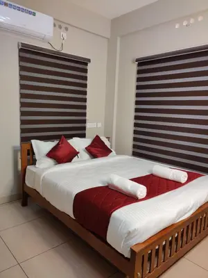 a bedroom with a large bed with red pillows at Dreams Arcade in Nedumbassery