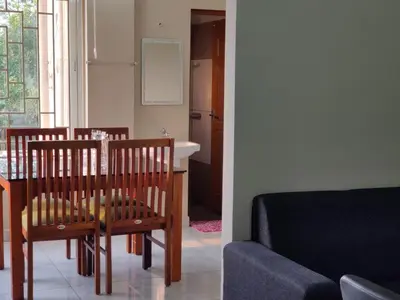 a living room with a table and chairs and a couch at Dreams Arcade in Nedumbassery