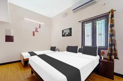 a bedroom with a black and white bed and a window at Collection O Ganapathy Athipalayam Pirivu Road in Coimbatore