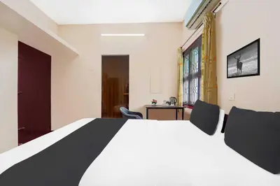 a bedroom with a large white bed in a room at Collection O Ganapathy Athipalayam Pirivu Road in Coimbatore