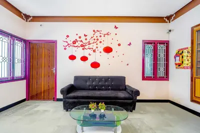 a living room with a couch and a glass table at Collection O Ganapathy Athipalayam Pirivu Road in Coimbatore