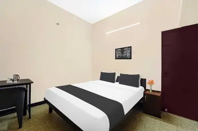 a bedroom with a bed and a desk and a bed at Collection O Ganapathy Athipalayam Pirivu Road in Coimbatore