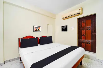 a bedroom with a white and black bed in a room at Collection O Erode VOC Park in Erode
