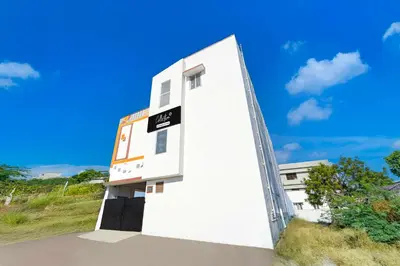 a white building with a sign on the side of it at Collection O Neelambur Near PSG ITech in Irugūr