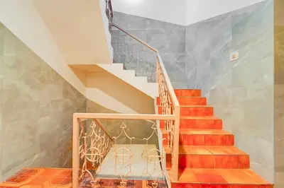 a staircase in a house with orange and gray walls at Collection O IIT College Coimbatore in Coimbatore