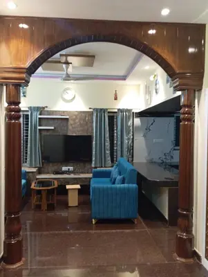 a living room with a blue couch and a table at Riddhi krrish Home stay in Mysore