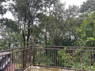 a metal fence with trees in the background at Aambal Wayanad Pool House Resort by Veda Retreat in Wayanad