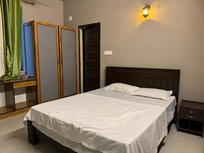 a bedroom with a large bed with white sheets at Aambal Wayanad Pool House Resort by Veda Retreat in Wayanad