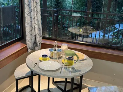 a small table with two glasses of juice on it at Aambal Wayanad Pool House Resort by Veda Retreat in Wayanad