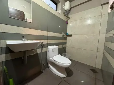 a bathroom with a toilet and a sink at Aambal Wayanad Pool House Resort by Veda Retreat in Wayanad