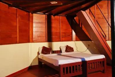 a bed in a room with wooden walls at THE DOCkSIDE INN in Madikeri