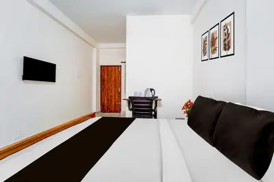 a living room with a couch and a tv at Super Collection O RS Puram North Railway Station Formerly RG Residency in Coimbatore