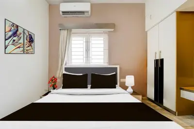 a bedroom with a black and white bed and a window at Hotel O Ondipudur Bus Terminal Formerly New Paradise Inn in Irugūr