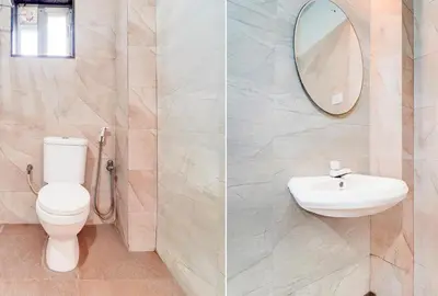 a bathroom with a toilet and a sink and a mirror at Hotel O Ondipudur Bus Terminal Formerly New Paradise Inn in Irugūr
