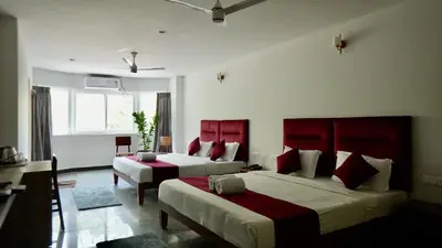 a bedroom with two beds with red headboards at Heritage Suites in Mysore