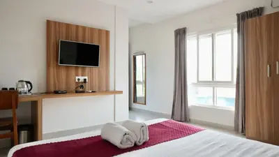 a hotel room with a bed with towels on it at Heritage Suites in Mysore