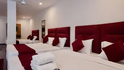 a hotel room with two beds with red headboards at Heritage Suites in Mysore
