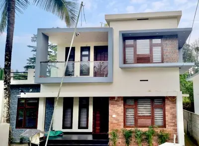 a house with a palm tree in front of it at Little Home in Sultan Bathery