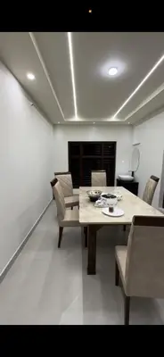 a dining room with a wooden table and chairs at Little Home in Sultan Bathery