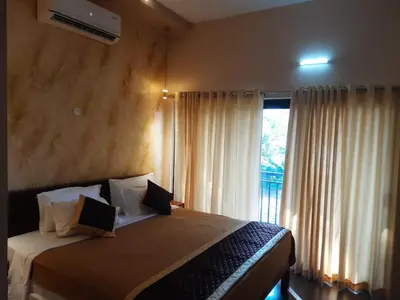 a bedroom with a bed and a window with curtains at Vipinam, The riverside retreat in Kotamangalam