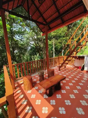 a deck with a wooden table and chairs on it at Reevilla in Madikeri