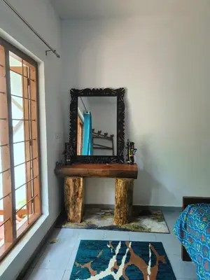 a mirror on a table in a room with a rug at Reevilla in Madikeri