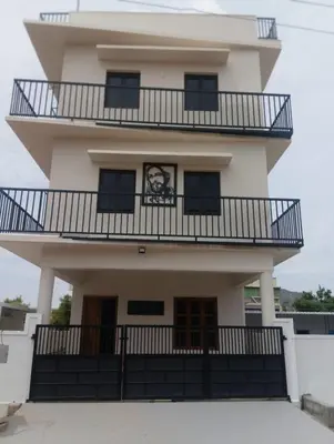 a building with a picture of a man on it at Joseph's Residency Homestay in Podanūr