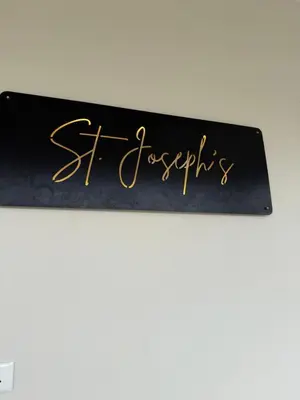 a black sign with gold writing on it at Joseph's Residency Homestay in Podanūr