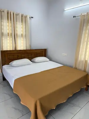 a bedroom with a large bed with two pillows at Joseph's Residency Homestay in Podanūr