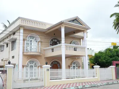 a house with a white fence in front of it at Raaha Luxury Home Stay in Mysore