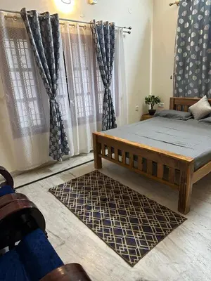 a bedroom with a bed and a large window at Raaha Luxury Home Stay in Mysore
